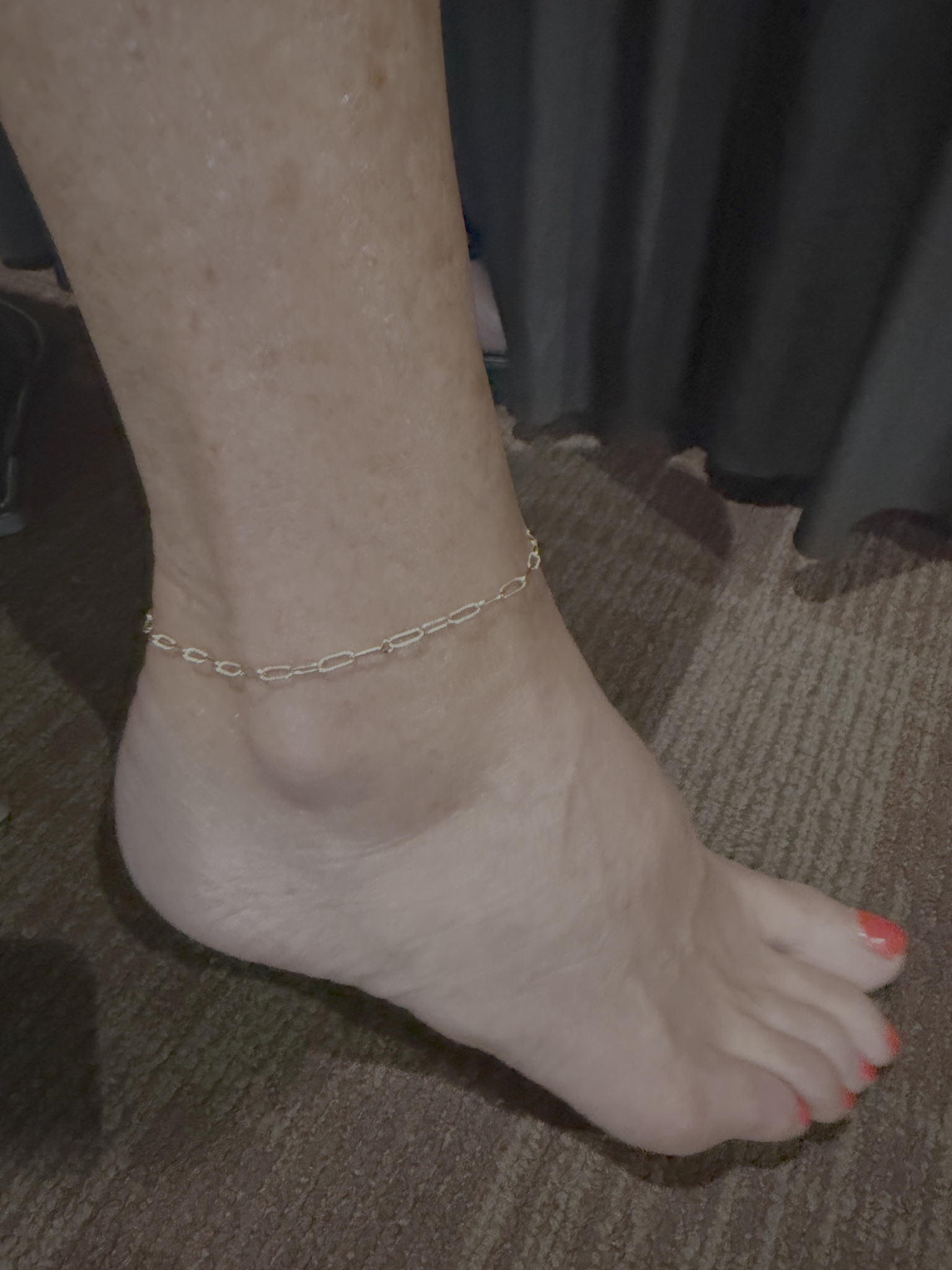 A textured oval link anklet worn on a bare ankle