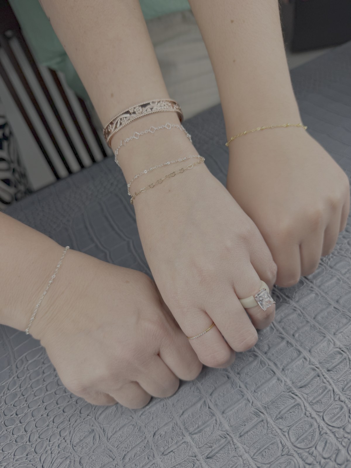 Several wrists wearing individual chain bracelet combinations