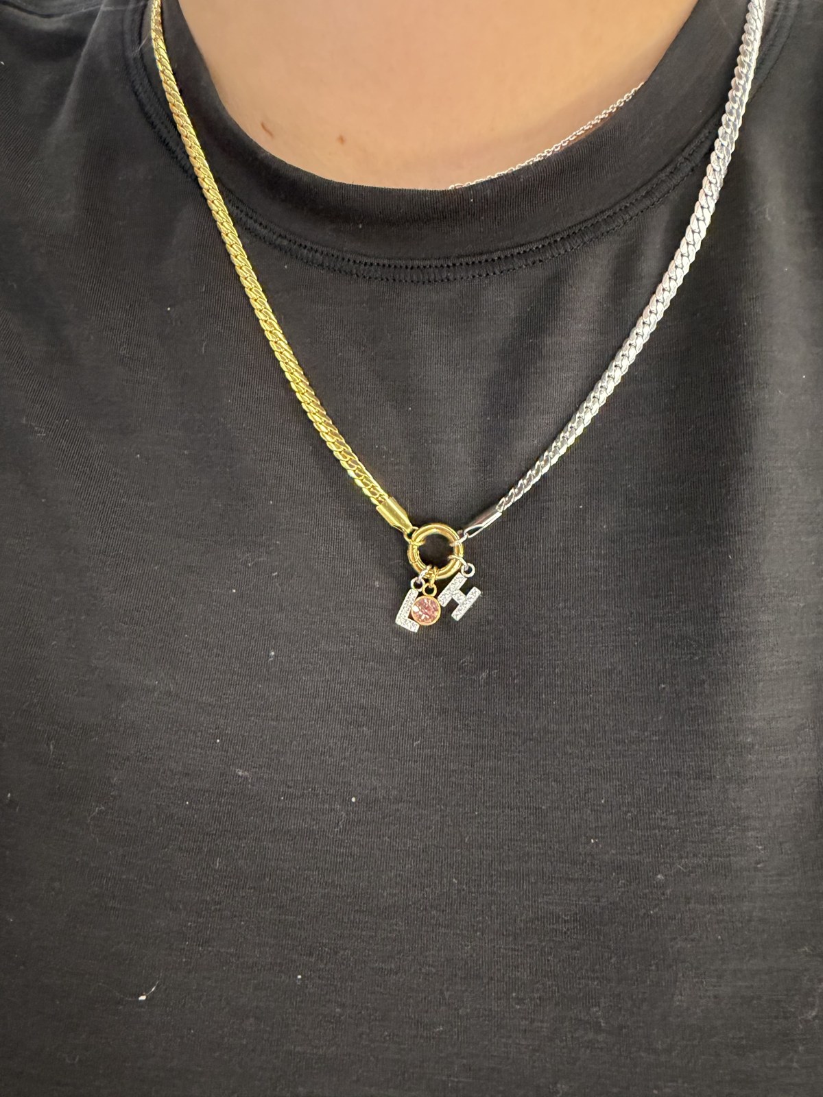 A necklace combining gold and silver colored chain with charms